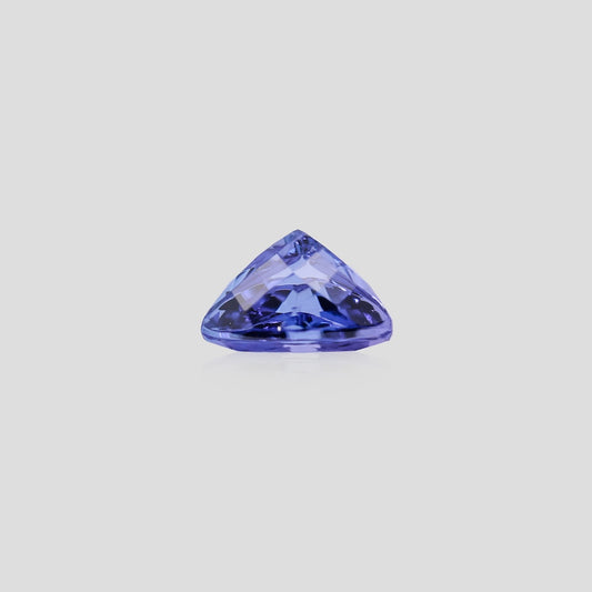 Triangular blue gemstone on a light gray background