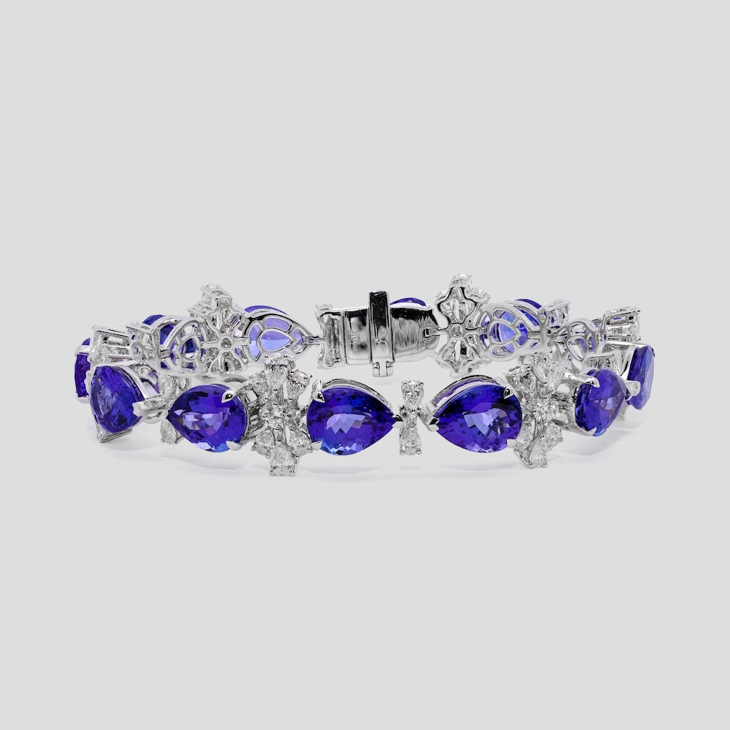 Jewelry bracelet with purple tanzanite gemstones and diamond accents on a light gray background