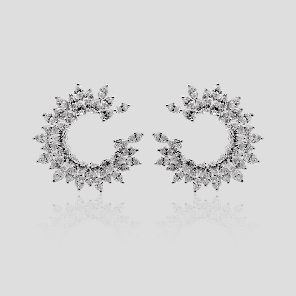 Pair of white gold hoop earrings with real diamonds on a light gray background