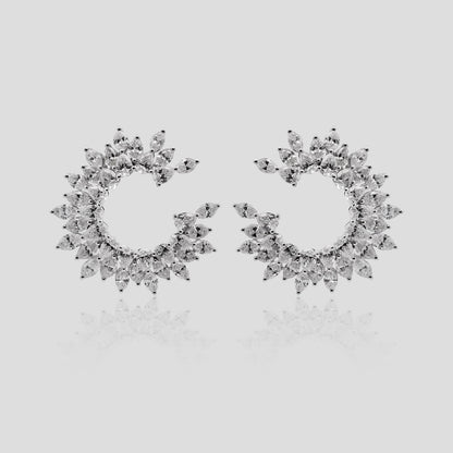 Pair of white gold hoop earrings with real diamonds on a light gray background