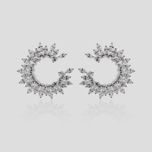 Pair of white gold hoop earrings with real diamonds on a light gray background