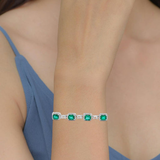 Emerald bracelet with diamond accents on a woman's wrist.