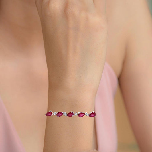 Ruby bracelet with diamonds on a woman's wrist against a neutral background