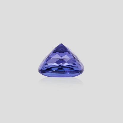 Cushion-shaped tanzanite purple gemstone on a light gray background
