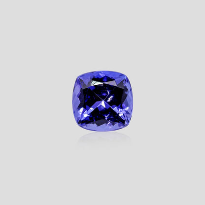 Cushion-cut blue tanzanite gemstone on a light gray background