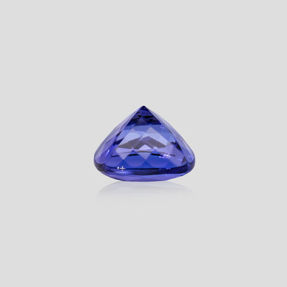 cushion-shaped tanzanite gemstone on a light gray background