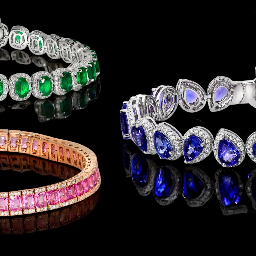 Three colorful gemstone bracelets on a reflective black surface