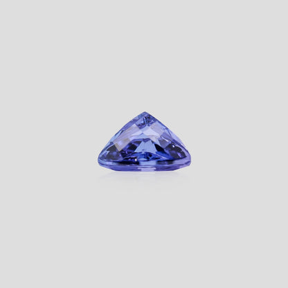 Triangular blue gemstone on a light gray background