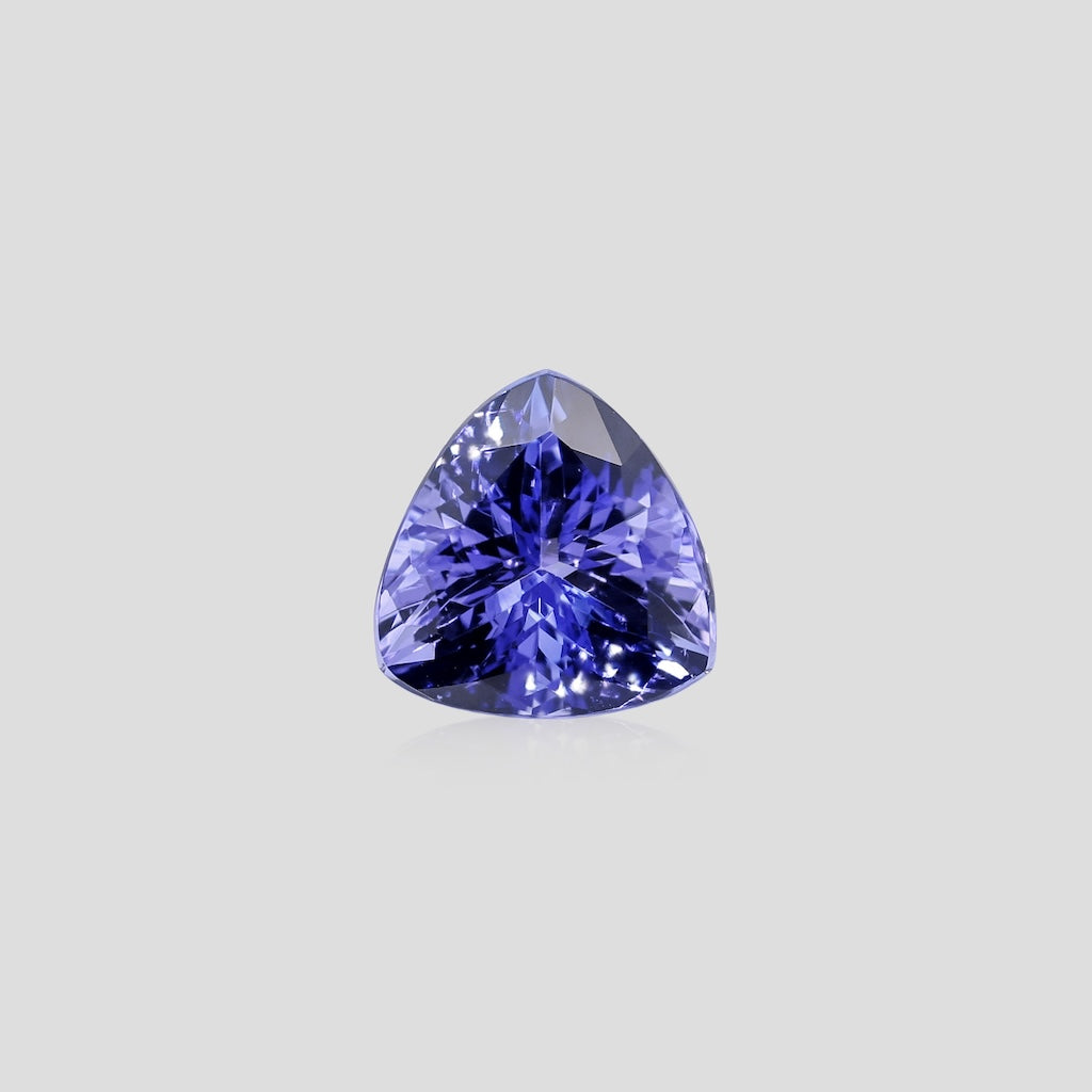 Trillion-shaped purple gemstone on a light gray background