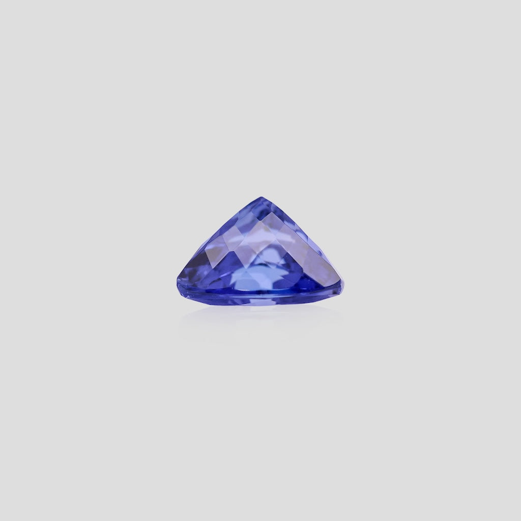 Trillion-shaped blue gemstone on a light gray background